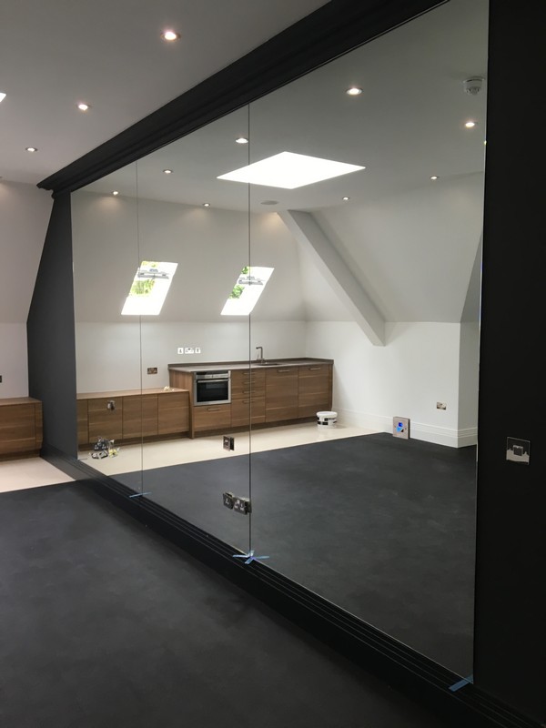 Frameless glass partition in loft conversion by Stanmore glaziers