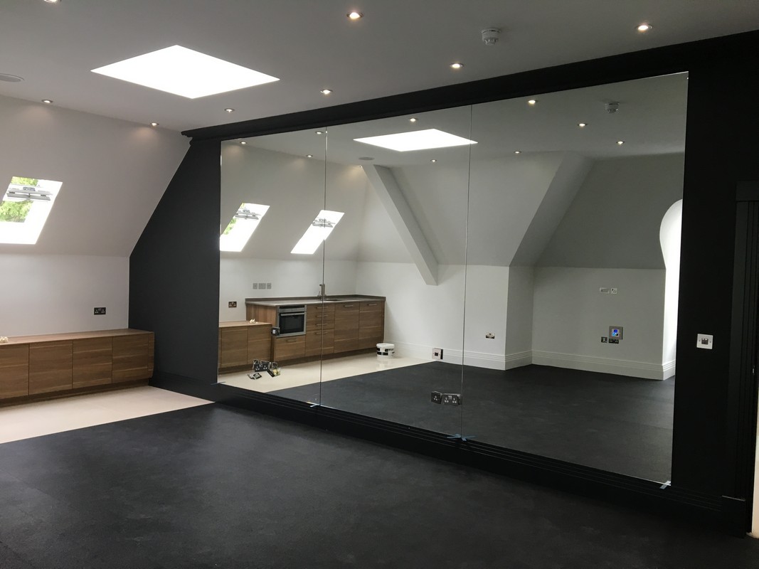 Frameless glass wall dividing loft conversion in Stanmore